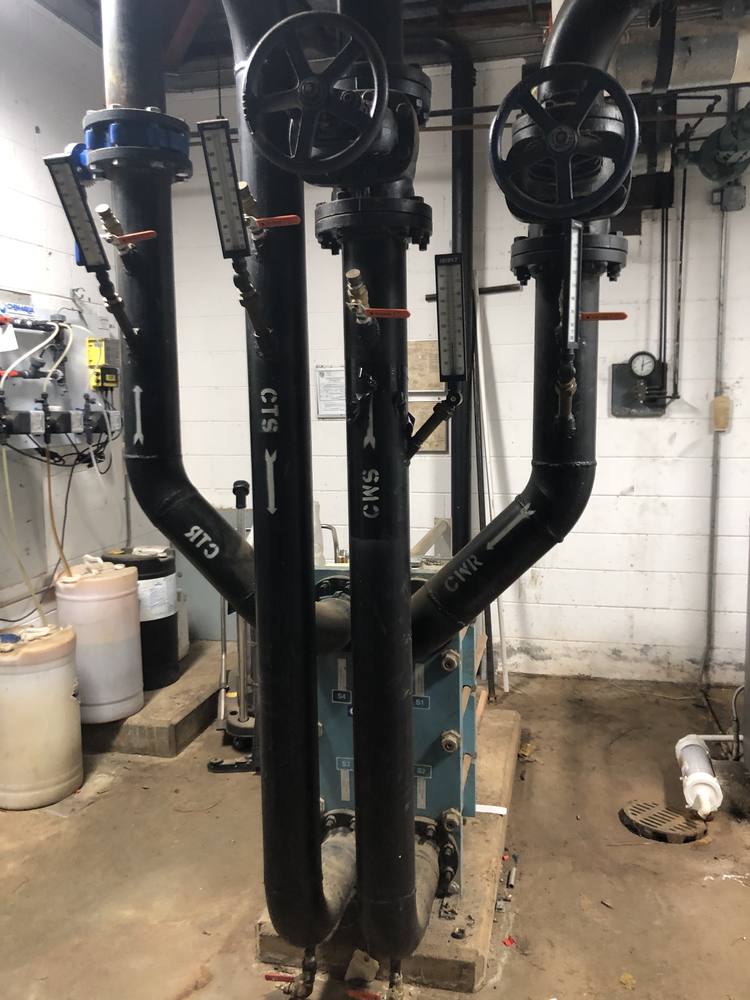 Chilled water piping and cooling tower with temperature sensors connected to AI controller